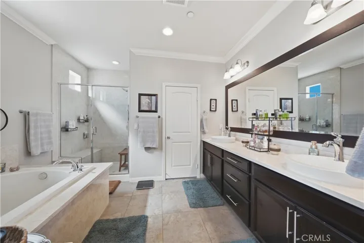 Large primary bathroom with dual sinks and separate shower and tub.