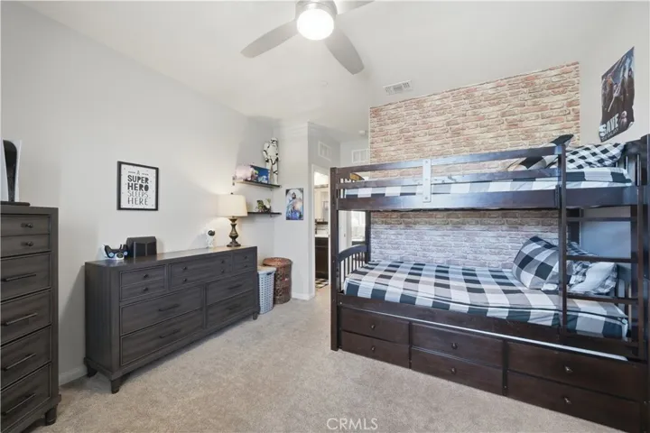 Spacious bedroom with ceiling fan and shared bathroom.