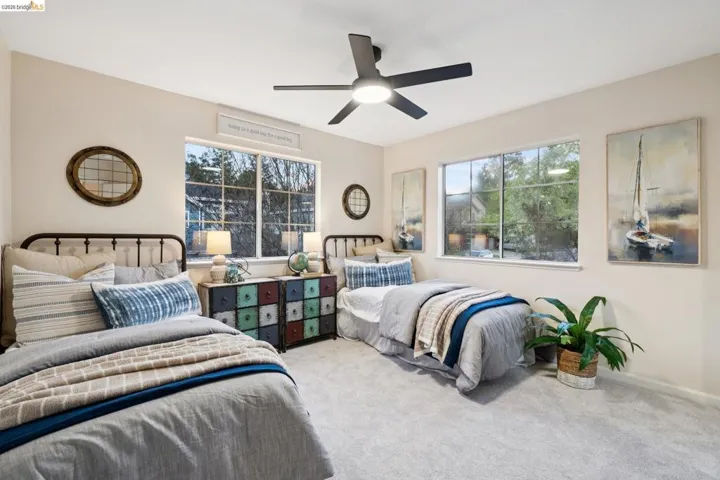 Carpeted bedroom featuring a ceiling fan and baseboards