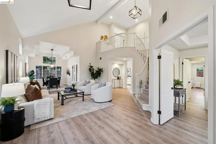 Living room with light wood-type flooring, recessed lighting, and vaulted ceiling