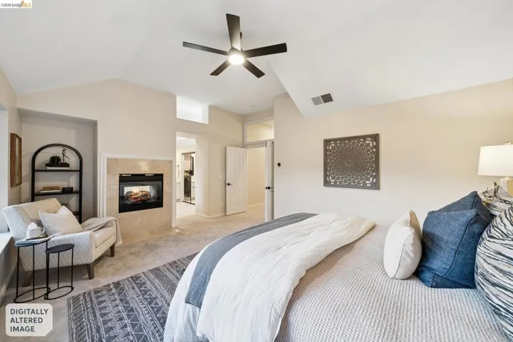 Carpeted bedroom with a fireplace and ceiling fan