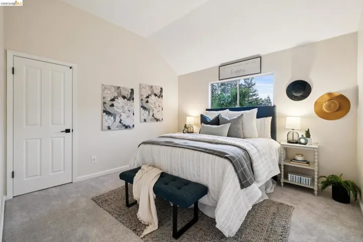 Carpeted bedroom featuring vaulted ceiling and baseboards