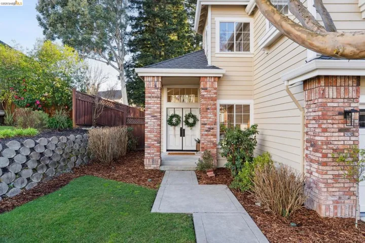 Property entrance featuring brick siding and roof with shingles