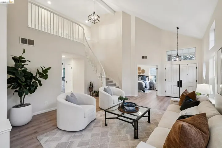Living area with wood finished floors, a chandelier, and lofted ceiling