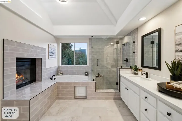 Full bathroom with a tiled fireplace, vanity, a shower stall, and a bath