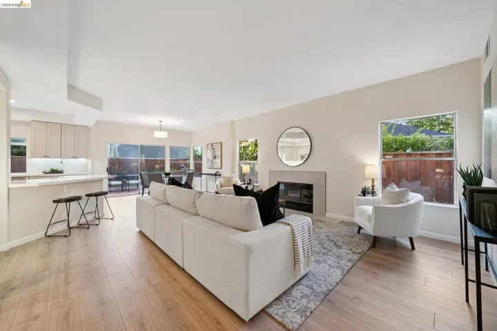 Living room with light wood-type flooring and a glass covered fireplace