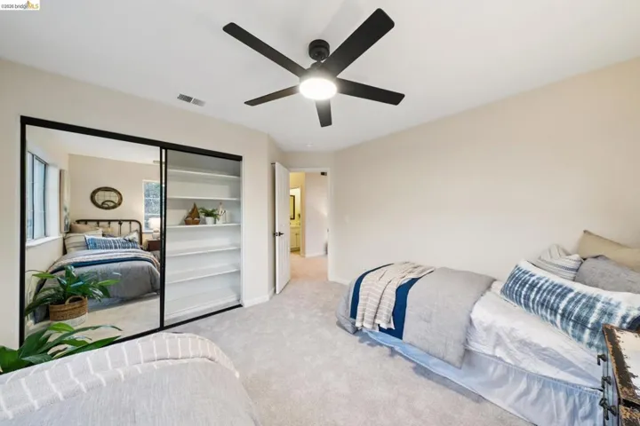 Bedroom with a closet, carpet, and a ceiling fan
