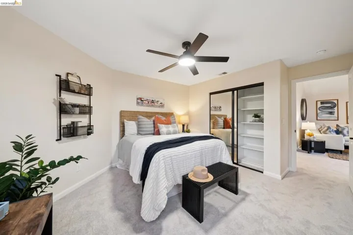 Bedroom featuring light carpet, ceiling fan, and a closet