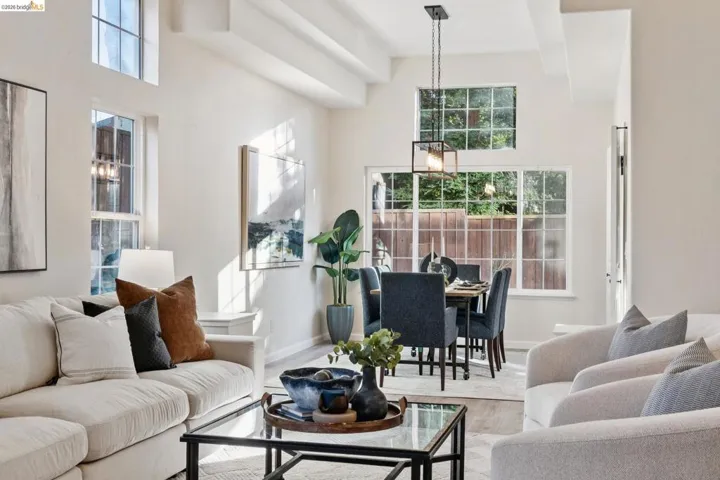 Living area featuring a high ceiling, wood finished floors, and plenty of natural light
