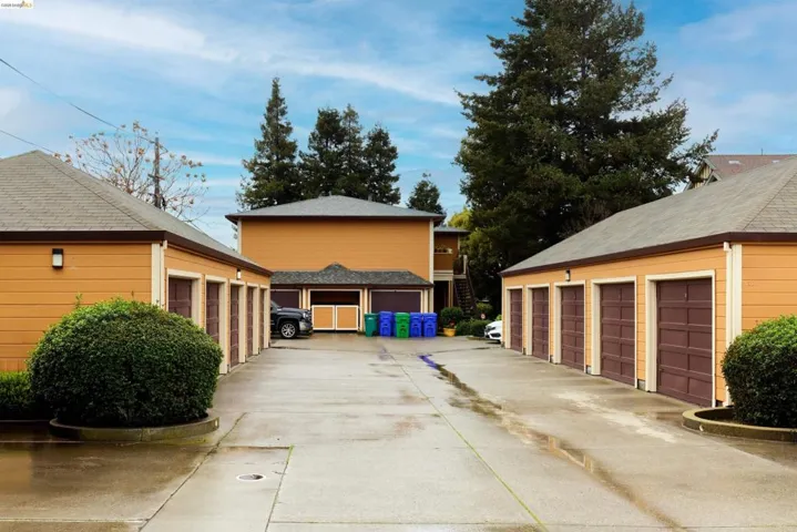 View of property exterior with community garages and an outbuilding