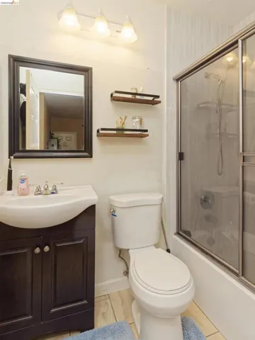 Bathroom featuring vanity and shower / bath combination with glass door
