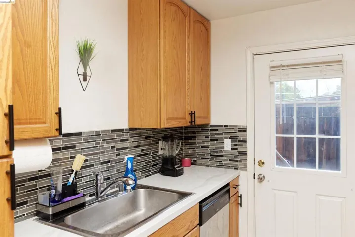 Kitchen featuring dishwasher, wood finish cabinetry, and tasteful backsplash