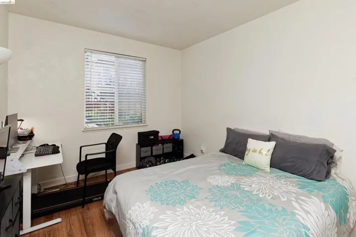 Bedroom featuring dark wood-style flooring and baseboards