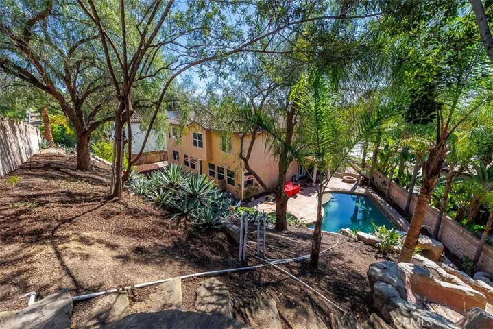 View from the top of the slope looking down toward the pool slide and pool. There is a sitting area at the top of the slope just to the left of this picture