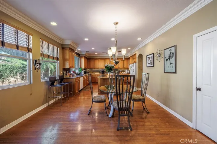 Casual dining area sits between the family room and the kitchen. Hardwood flooring, high ceilings with crown molding, and recessed lighting