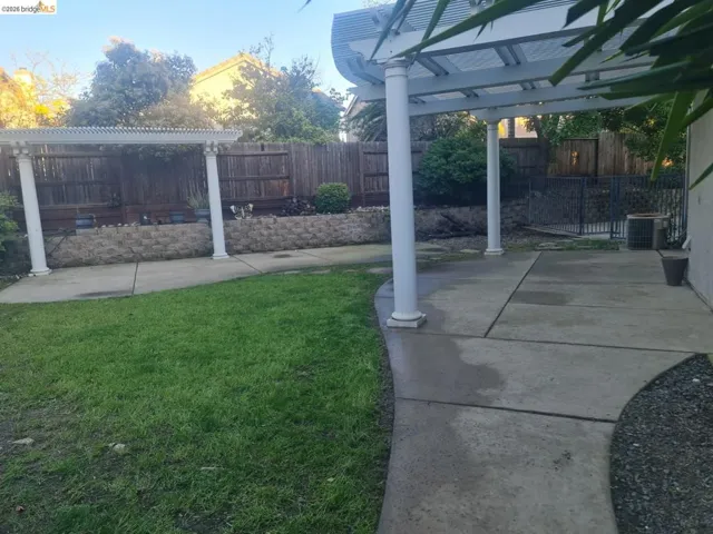 Fenced backyard featuring a patio and a pergola