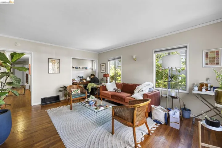 Living room with hardwood / wood-style flooring and ornamental molding