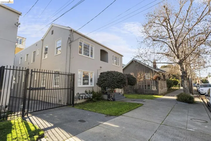 View of front facade with stucco siding and a gate