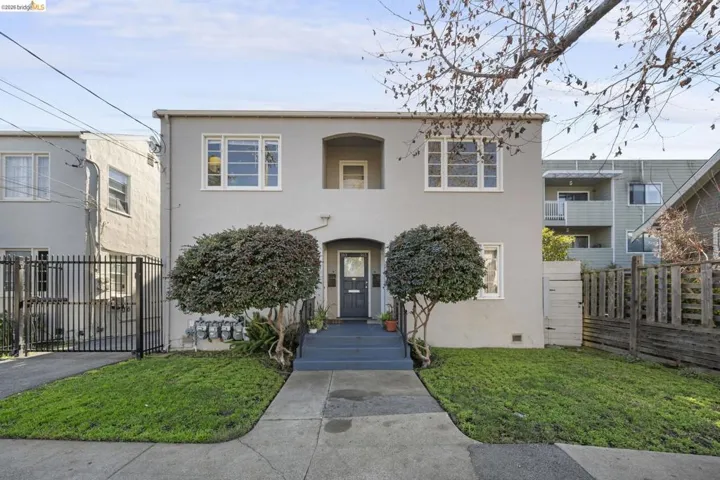 View of front of property with stucco siding and a gate