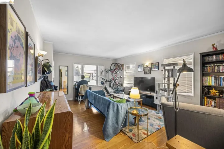 Living room featuring wood finished floors and crown molding