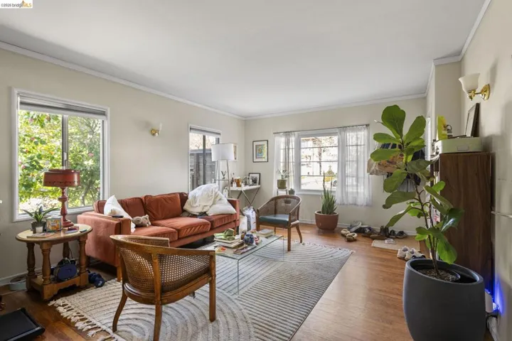 Living room featuring wood finished floors and crown molding