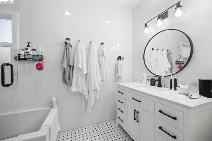 Bathroom featuring vanity and shower / bath combination with glass door