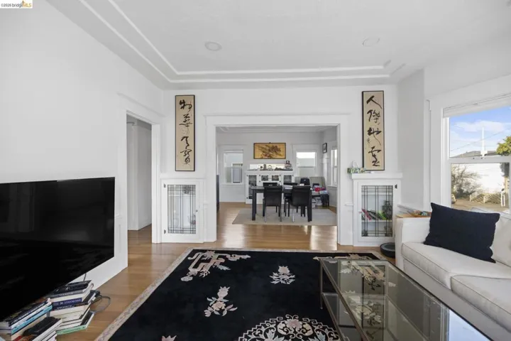 Living room featuring wood finished floors, a tray ceiling, and plenty of natural light