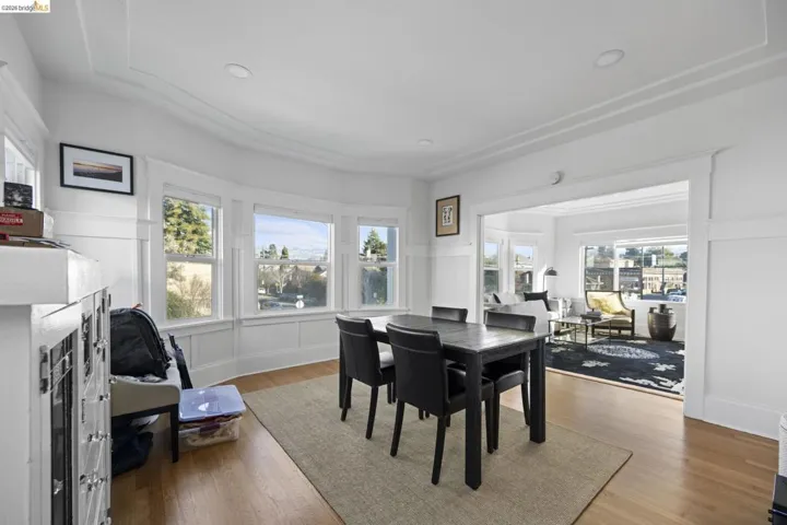 Dining room with light wood-style flooring, a decorative wall, and recessed lighting