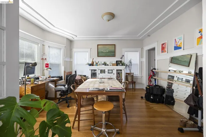 Office with wood finished floors and a tray ceiling