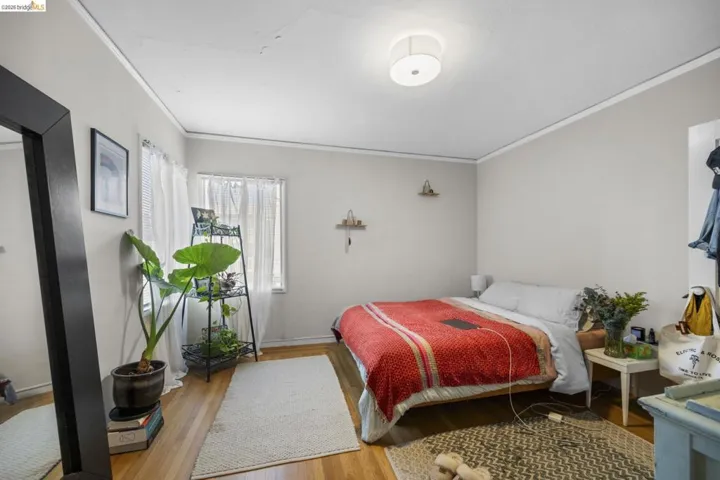 Bedroom featuring wood finished floors and ornamental molding