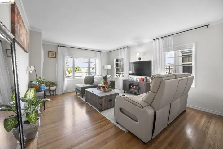Living room with ornamental molding and hardwood / wood-style flooring