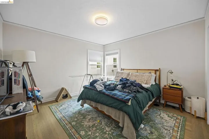 Bedroom with hardwood / wood-style floors and crown molding