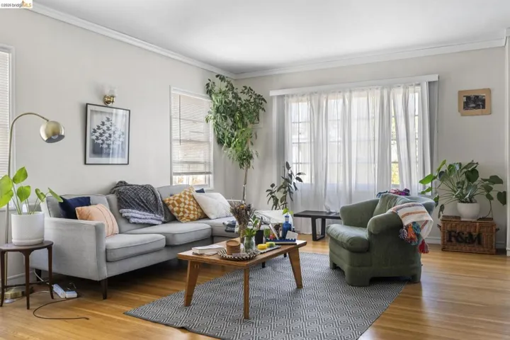Living room featuring ornamental molding, light wood-style floors, and healthy amount of natural light