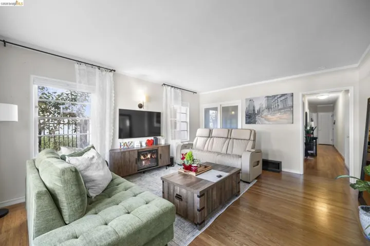 Living room featuring wood finished floors, plenty of natural light, and crown molding