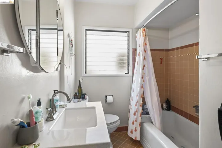 Full bath with shower / bath combination with curtain, vanity, and tile patterned floors