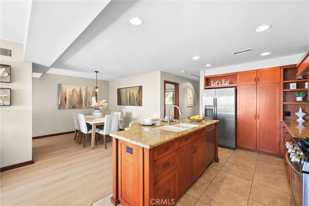 A view of the open remodeled kitchen, the kitchen island with seating for 2 and the dining room beyond.