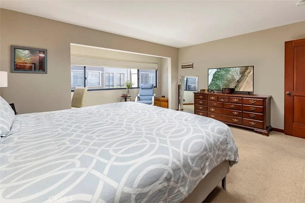 A view of the large primary bedroom suite from the bathroom, the alcove is frequently used as an office space.