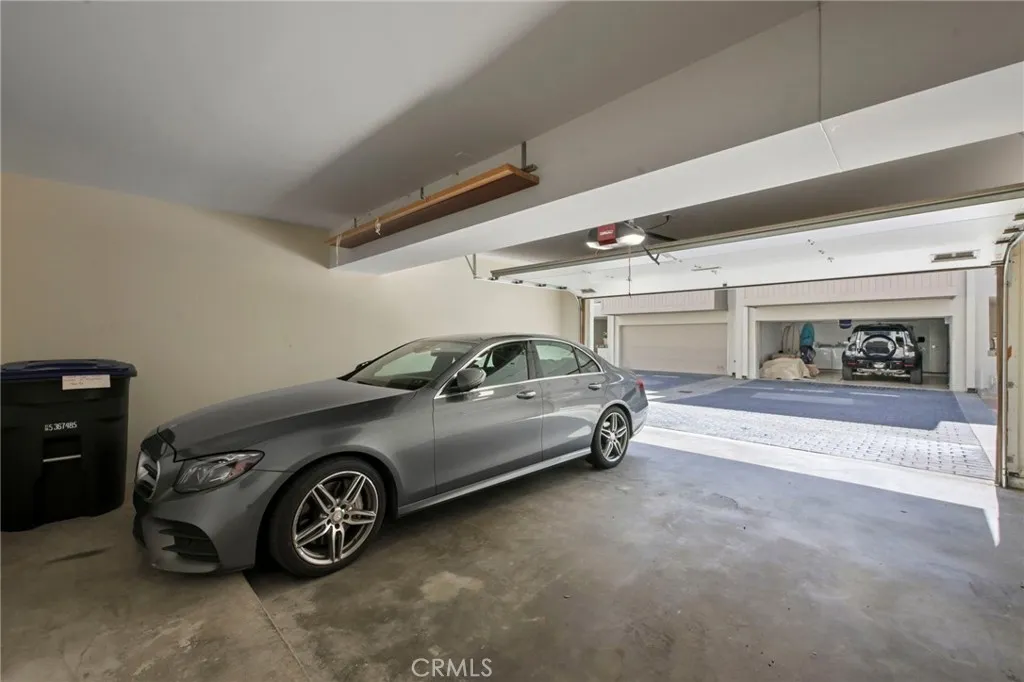 Spacious 2 car garage with storage closet and storage space on the right side of the garage.