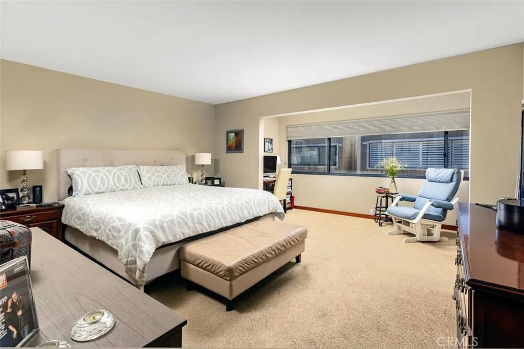 The primary bedroom with an alcove beyond that has room for an office or sitting area.