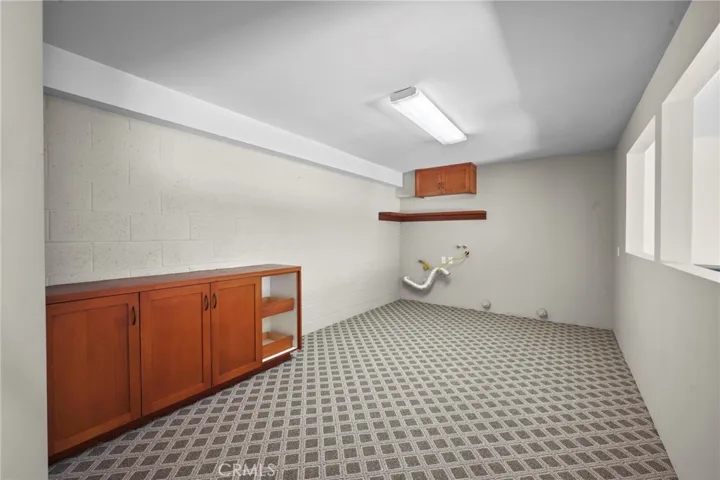 Bonus room off the garage with brand new carpeting, a built-in cabinet for storage and laundry facilities at the far end of this room. Could be a great work out room or movie room!