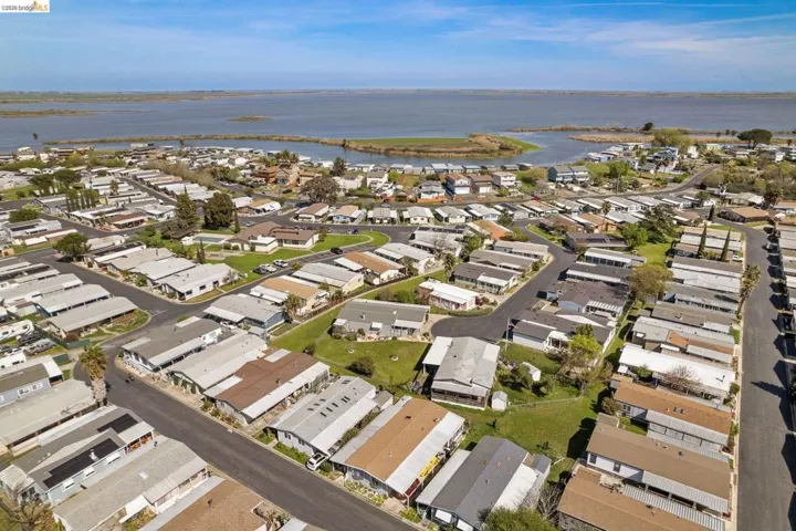 Aerial overview of property's location featuring a large body of water and nearby suburban area