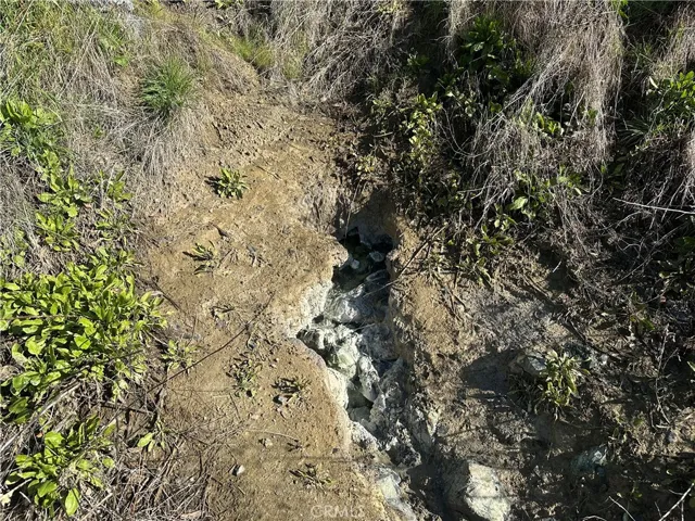 The hot spring comes out of the ground just above the road. Listing agent estimates the flow when the photo was taken at 10-15 GPM