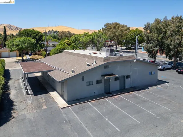 View of property with a mountain view and uncovered parking