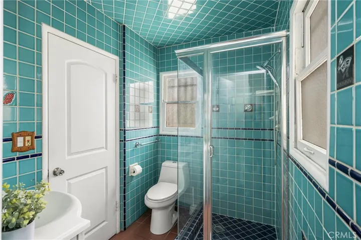 Attached primary bathroom with built-in heater and door to laundry room
