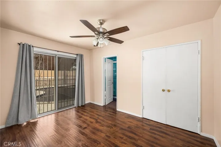 Primary bedroom with slider to backyard, door to attached bathroom and double door closet