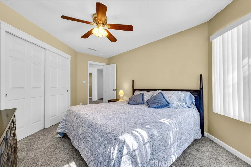 Bedroom with large closet space and ceiling fan.