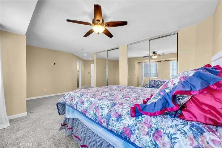 Master bedroom with lots of closet space.  Matching mirrored closets plus ceiling fan.