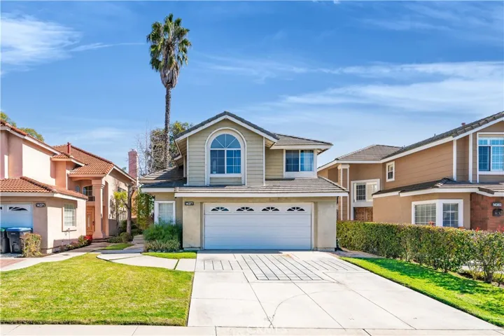 Clean curb appeal with a wide driveway, fresh lawn, and classic two-story design that feels welcoming from the street.