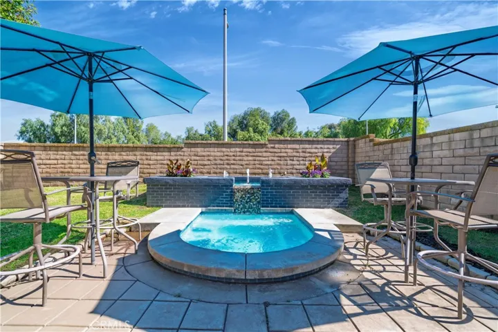 The resort-style spa with water features creates a relaxing focal point in the yard.