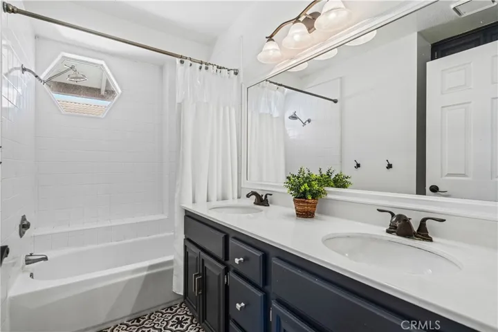 A full upstairs bath with dual sinks and clean tile finishes serves the secondary bedrooms.
